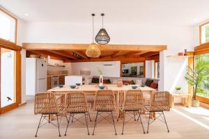 een keuken en eetkamer met een houten tafel en stoelen bij Villa estilo Mediterráneo in Calpe
