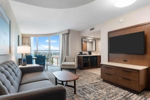 a living room with a couch and a television at Embassy Suites by Hilton Anaheim South in Anaheim