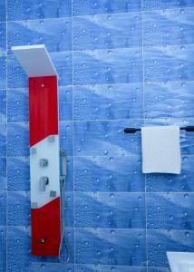 ein rot-weißes Objekt an einer blauen Wand mit Wassertropfen in der Unterkunft HOTEL MAVILLA Cotonou in Cotonou + 48 Fotos