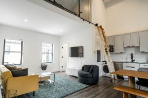 an open living room with a kitchen and a ladder at The Loft @ Columbus Center in Columbus