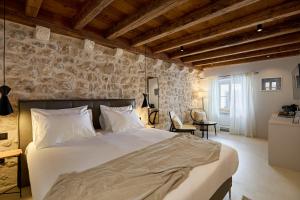 ein Schlafzimmer mit einem großen Bett und einer Steinwand in der Unterkunft Modern Stone House, luxury suites in Dubrovnik Old Town in Dubrovnik