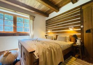 Schlafzimmer mit einem großen Bett mit einem Kopfteil aus Holz in der Unterkunft Hájenka Libín in Prachatice