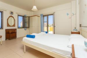 ein großes Schlafzimmer mit 2 Betten und einem Spiegel in der Unterkunft Panormos Villas Collection in Panormos