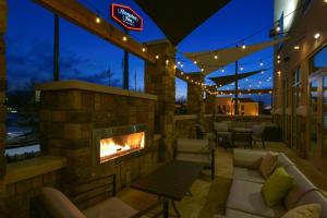 d'une terrasse avec une cheminée, des chaises et des tables. dans l'établissement Hampton Inn Lumberton, NC, à Lumberton