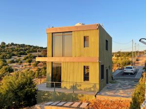 ein Haus mit gelber Fassade auf einem Hügel in der Unterkunft Shams Farm in Adschlun