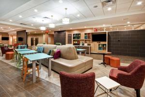 eine Lobby mit einem Sofa, Tischen und Stühlen in der Unterkunft Home2 Suites By Hilton Columbus Downtown in Columbus