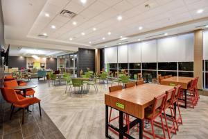 a dining room with tables and chairs in a building at Home2 Suites By Hilton Columbus Downtown in Columbus