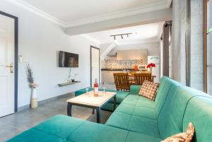 Villa Deniz Paradise في داليان: غرفة معيشة مع أريكة زرقاء وطاولة