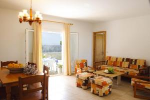 un soggiorno con divano, tavolo e sedie di Villa Roca Nova a Cacla D'or