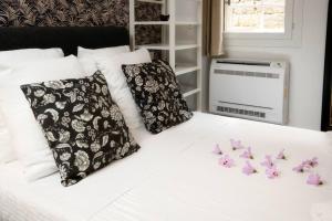 łóżko z czarno-białymi poduszkami i fioletowymi kwiatami w obiekcie La Tour de Bohémond w Carcassonne
