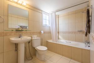 新喬里歐的住宿－Villa Amorosa，浴室配有卫生间、盥洗盆和浴缸。