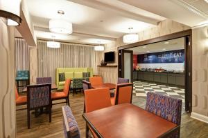 列克星敦的住宿－萊剋星頓I-75漢普頓酒店，一间带桌椅的餐厅和一间酒吧