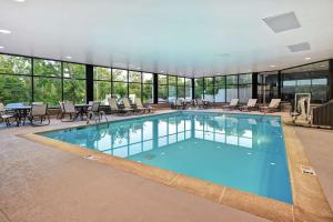 列克星敦的住宿－萊剋星頓I-75漢普頓酒店，大楼内带桌椅的大型游泳池