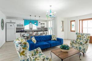 a living room with a blue couch and two chairs at Villa Portakal Blossom in Dalyan
