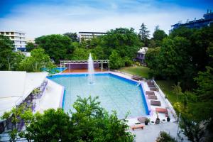 a large swimming pool with a fountain in a city at Hotel RIVA in Golden Sands