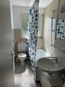 a bathroom with a toilet and a tub and a sink at Moderne Service Apartment AVD3 in Gelsenkirchen