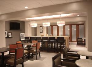 a restaurant with tables and chairs and a bar at Hampton Inn Lexington Medical Center, KY in Lexington