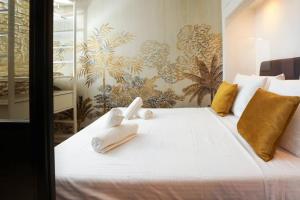 - une chambre avec un grand lit blanc et des serviettes dans l'établissement Le Palais d'Aliénor - parking gratuit, à Carcassonne