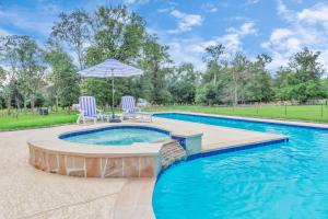 a swimming pool with two chairs and an umbrella at Bespoke Outdoor Bubbles in Cleveland