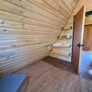 ein kleiner Holzraum mit einer Holzwand in der Unterkunft Cabaña de huéspedes en un microviñedo familiar in Rauco