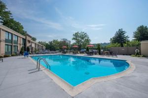 a swimming pool at a resort with tables and chairs at Hotel MTK Mount Kisco in Mount Kisco