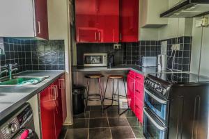 a kitchen with red cabinets and stools in it at Vintage Room-Only Room in London