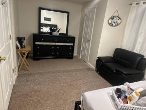 a living room with a black couch and a mirror at Home away from home! in Canton