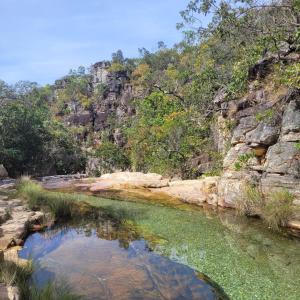 una piscina de agua en un río junto a una montaña en Hostel do Cerrado, en Cavalcante
