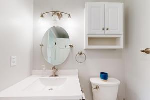 a white bathroom with a sink and a mirror at Cozy Family Home in Penn Yan +21 photos
