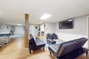 a living room with couches and a flat screen tv at Cozy Family Home in Penn Yan