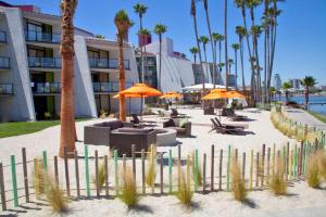 a beach with chairs and umbrellas and palm trees at Hotel Maya - a DoubleTree by Hilton Hotel in Long Beach