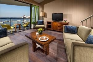 a living room with two couches and a television at Hotel Maya - a DoubleTree by Hilton Hotel in Long Beach