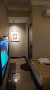 Habitación con TV de pantalla plana y cama. en Najmi Inn Hotel, 