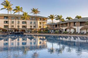 una gran piscina con palmeras frente a un edificio en Hilton Vacation Club The Point at Poipu Kauai, en Koloa