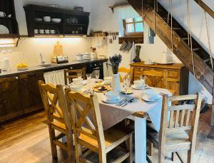a kitchen with a table with chairs and a tableablish at Hájenka Libín in Prachatice