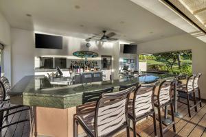 a kitchen and living room with a bar with chairs at Hilton Vacation Club The Point at Poipu Kauai in Koloa