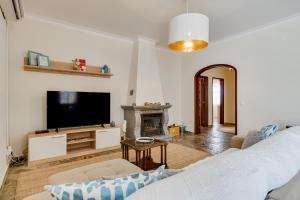 salon z telewizorem i kominkiem w obiekcie Quinta do Quartel w mieście Évora