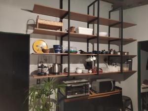 a kitchen with wooden shelves and a microwave at Hostel do Cerrado in Cavalcante