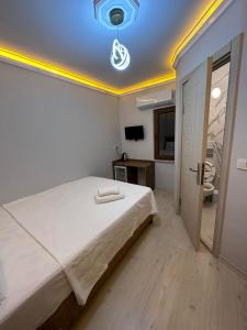 een slaapkamer met een groot bed met een licht aan het plafond bij pilot hotel in Arnavutköy