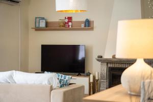 a living room with a tv and a couch and a fireplace at Quinta do Quartel in Évora