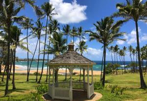 a gazebo on the beach with palm trees at Hilton Garden Inn Kauai Wailua Bay, HI in Kapaa