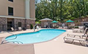 a large swimming pool with chairs and a building at Hampton Inn Maumelle in Maumelle