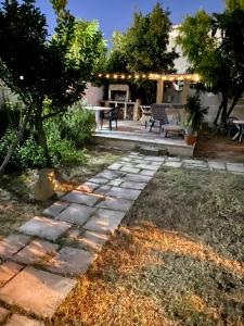 un jardin avec une passerelle en pierre et une terrasse dans l'établissement Salento Appartamenti, à Casalabate