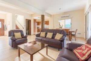 Sala de estar con 2 sofás y mesa de centro en Rose Villas Collection, en Kato Yialia