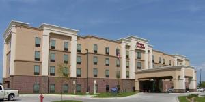 un gran edificio con una bandera americana delante de él en Hampton Inn and Suites - Lincoln Northeast, en Lincoln