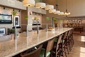 a long bar with chairs and a long table in a room at Hampton Inn and Suites - Lincoln Northeast in Lincoln