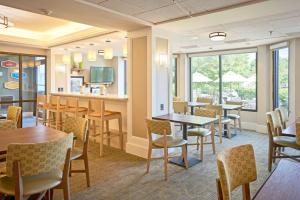 a dining room with tables and chairs and windows at Hampton Inn Lancaster in Lancaster