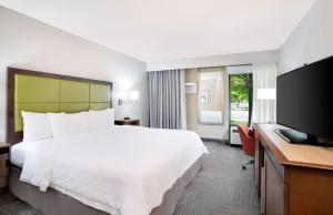 a hotel room with a bed and a flat screen tv at Hampton Inn Lancaster in Lancaster