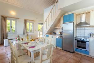a kitchen with a table and a kitchen with blue cabinets at Maria Beach House in Dhamoulianáta