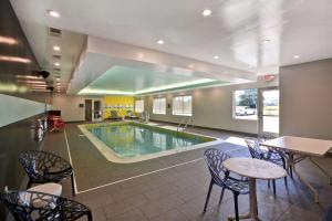 Denver的住宿－Tru By Hilton Denver, PA，游泳池位于酒店客房内,配有椅子和桌子